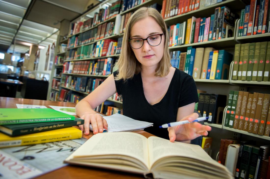 PHonors Summer Research Grant recipient Madeline Ninno, who is double majoring in economics and international development in the School of Liberal Arts, is pictured doing library research.
